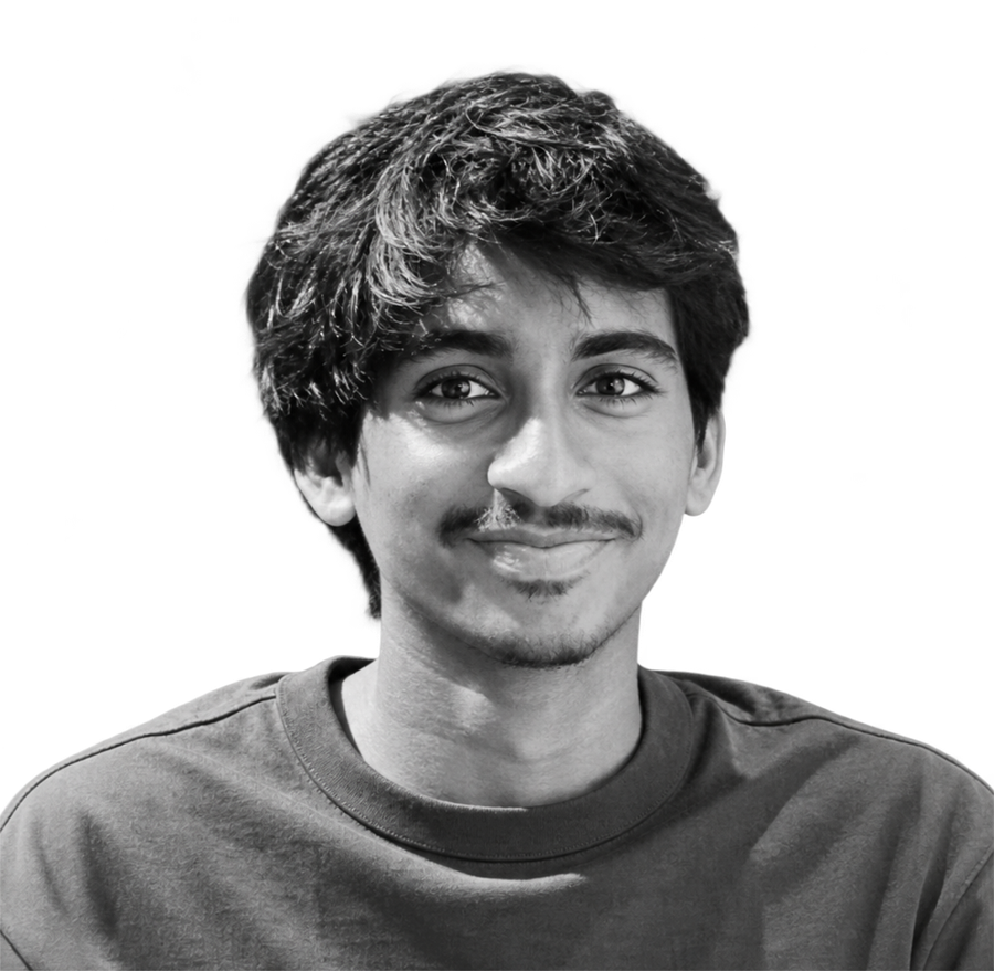 Black-and-white portrait of Aain Husham, owner of Fuku Coffee, smiling at the camera in a plain crew-neck tee.
